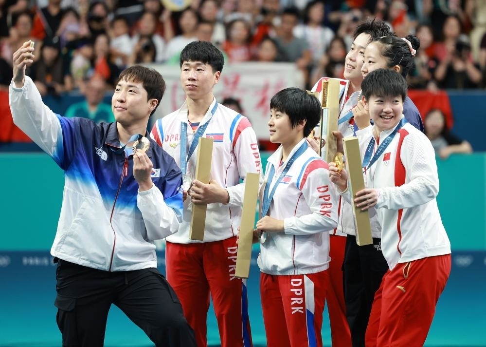 冠軍中國組合王楚欽（右三）/孫穎莎（右一）、亞軍朝鮮組合李正植（左二）/金琴英（左三）、季軍韓國組合林鐘勛（左一）/申裕斌在巴黎奧運(yùn)會(huì)乒乓球混雙頒獎(jiǎng)儀式上合影（2024年7月30日攝）。新華社記者 劉續(xù) 攝