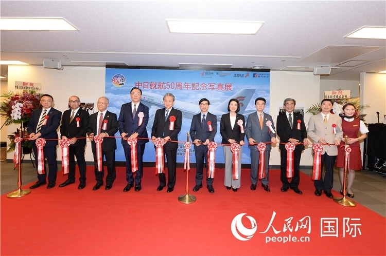與會嘉賓共同為中日通航50周年紀念圖片展開幕剪彩。馮學(xué)敏攝