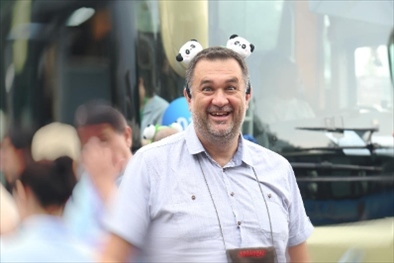 參訪熊貓谷前，塞爾維亞“一帶一路”研究所所長博揚(yáng)·拉利奇戴上熊貓頭飾。（李佩藺 攝）