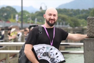 俄羅斯塔斯社執(zhí)行編輯葉夫根尼·扎多羅日內(nèi)在都江堰魚嘴拍照留念。（李佩藺 攝）