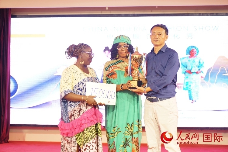 中國(guó)駐尼日利亞使館文化參贊兼中國(guó)文化中心主任李旭大（右）為最佳表現(xiàn)獎(jiǎng)?lì)C獎(jiǎng)（中）。人民網(wǎng)記者 姜宣攝