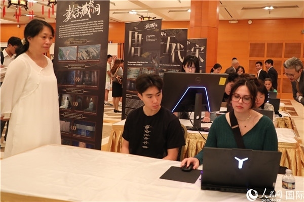 在活動(dòng)現(xiàn)場(chǎng)，當(dāng)?shù)孛癖婓w驗(yàn)“數(shù)字藏經(jīng)洞”云游戲，沉浸式體驗(yàn)敦煌文化。 人民網(wǎng)記者 李志偉攝