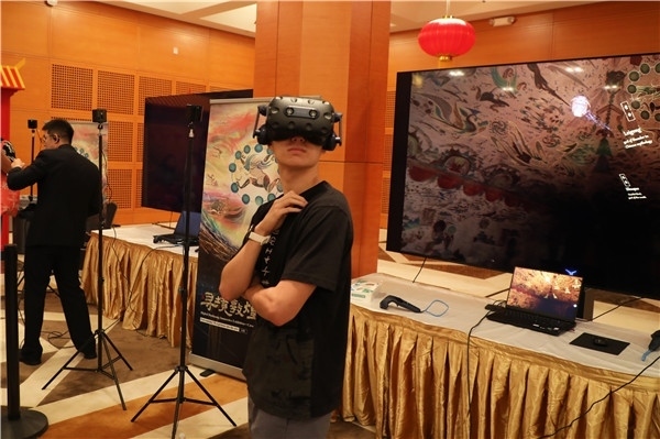 1、在本次活動(dòng)的展覽現(xiàn)場(chǎng)，敦煌研究院與騰訊展示了“數(shù)字藏經(jīng)洞”和“尋境敦煌”等創(chuàng)新互動(dòng)產(chǎn)品。圖為當(dāng)?shù)孛癖娡ㄟ^(guò)VR虛擬游覽洞窟。 人民網(wǎng)記者 李志偉攝