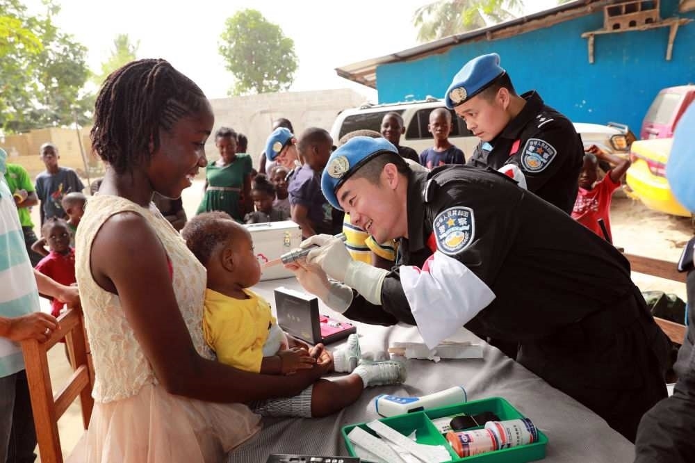 2017年12月28日，在利比里亞蒙羅維亞，中國維和警察防暴隊(duì)醫(yī)療人員為兒童做口腔檢查。