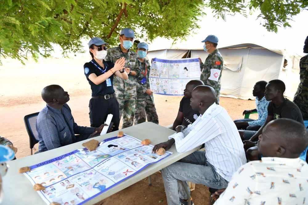 2020年3月，在南蘇丹首都朱巴，執(zhí)行聯(lián)合國維和任務(wù)的中國維和警察廖潔給當(dāng)?shù)鼐熘v解防疫知識(shí)。