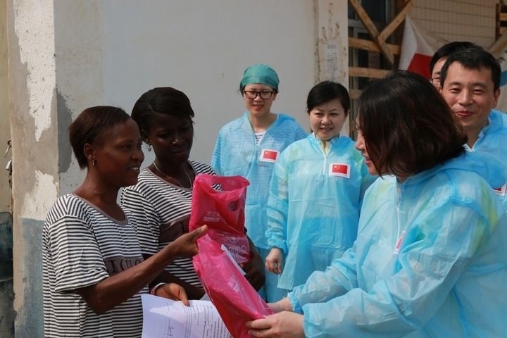 2015年4月4日，在位于塞拉利昂首都弗里敦市郊的中塞友好醫(yī)院埃博拉診療中心，中國第四批援塞醫(yī)療隊副隊長邵蔚（右前）向被治愈的埃博拉出血熱患者贈送禮物。新華社發(fā)（祖榮強 攝）