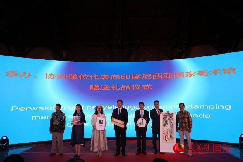 在展覽開幕式現(xiàn)場，本次展覽的承辦、協(xié)辦單位代表向印尼國家美術館贈送禮品。人民網記者 曹師韻攝
