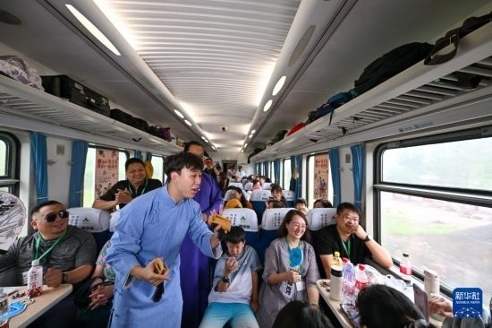 9月7日，相聲演員在S910列車上為旅客表演快板。