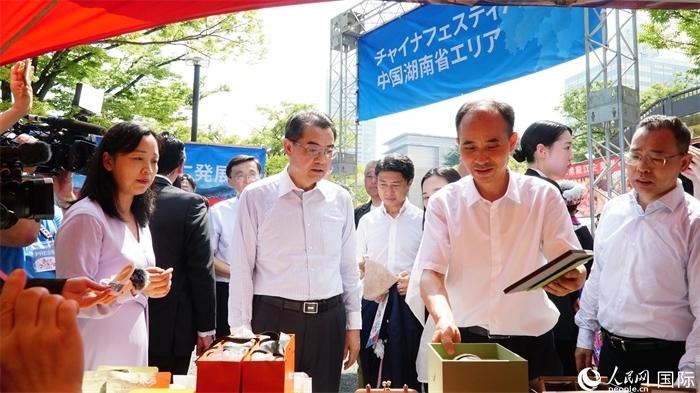 湖南展位工作人員向中國駐日本大使吳江浩介紹特色文創(chuàng)產(chǎn)品。人民網(wǎng) 蔣曉辰攝