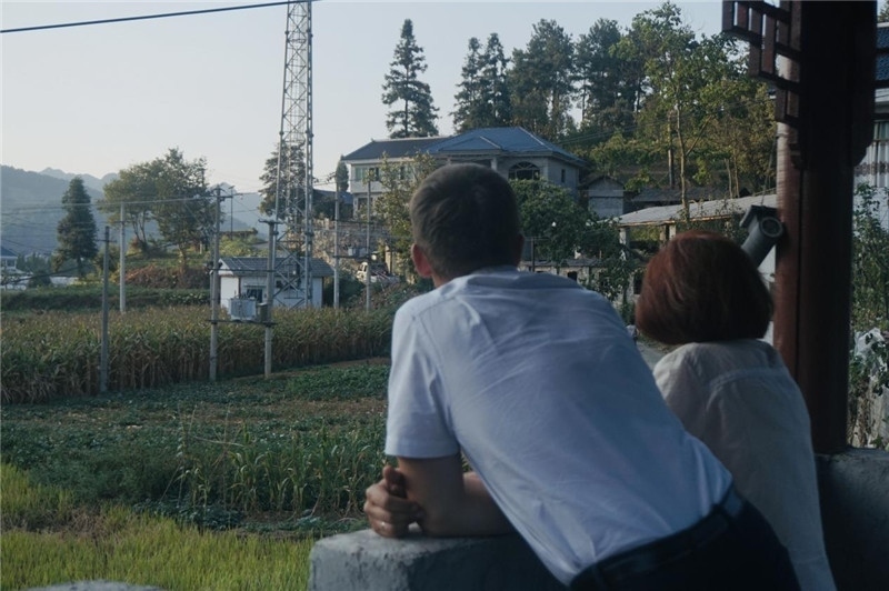 望得見山，看得見水，記得住鄉(xiāng)愁。每個(gè)人心中都有一個(gè)屬于自己的“花茂村”，在這方心田，走遍千山萬(wàn)水，鄉(xiāng)音未改鬢毛衰。吉爾吉斯斯坦《比什凱克晚報(bào)》第一副總編輯妮娜·尼奇博洛娃與《中國(guó)與俄羅斯》雜志社社長(zhǎng)奧列格·別列日內(nèi)赫攝在花茂村民居屋檐下并肩佇立，眺望山水，尋覓鄉(xiāng)愁。（李光裕攝）