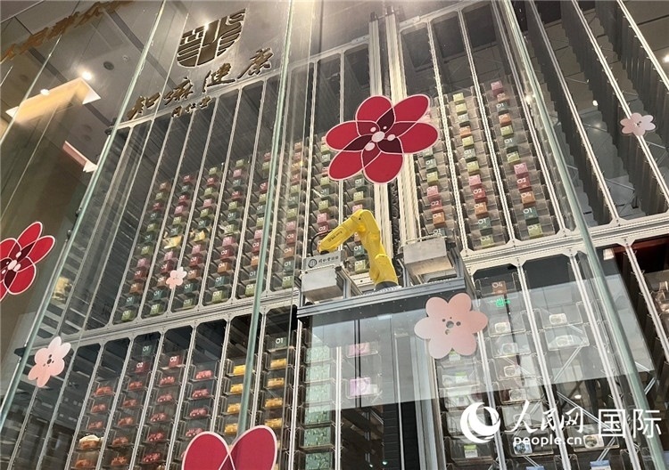 6. 機(jī)械臂正在取貨。（人民網(wǎng)記者陳思 攝）