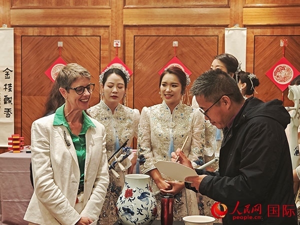 現(xiàn)場的非遺傳承人為英國觀眾展示畫技。人民網(wǎng)記者 邢雪攝