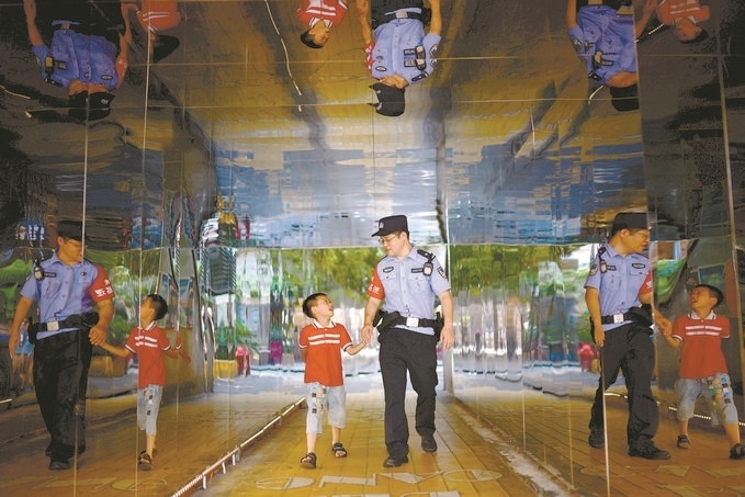 ?7月16日，重慶市公安局江北區(qū)分局一名民警在巡邏途中遇到一個獨自玩耍的小男孩，民警將其送回家。王洪平攝