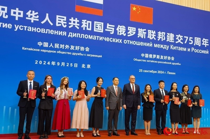 楊萬明會長和莫爾古洛夫大使為10位中俄青年友好微視頻創(chuàng)意大賽獲獎代表頒獎。人民網(wǎng)記者 李明琪攝