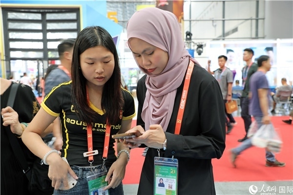 東博會現(xiàn)場，馬來西亞展商在同中方工作人員交談。人民網(wǎng)記者 趙益普攝