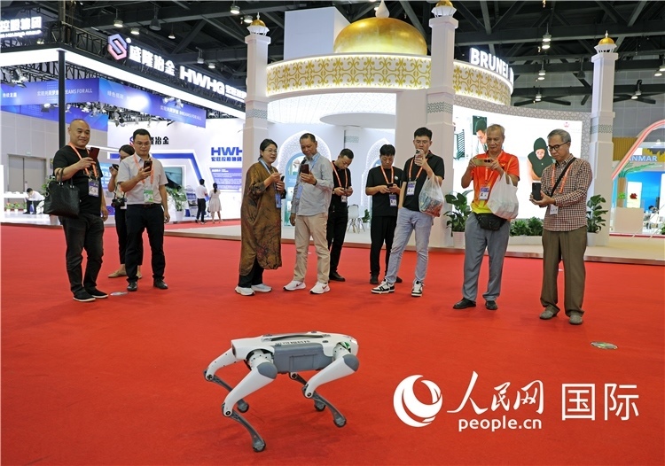 東博會(huì)上，觀眾正在參觀一只機(jī)器狗。綠色能源、新能源汽車、綠色農(nóng)產(chǎn)品等成為本屆東博會(huì)觀眾關(guān)注的焦點(diǎn)。人民網(wǎng)記者 趙益普攝