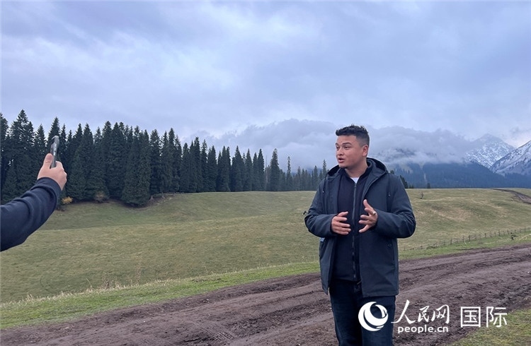 在庫爾德寧，吾買爾江被雪山美景震撼，即興錄制了短視頻作品。人民網(wǎng)記者曾書柔攝