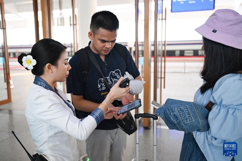 10月12日，在老撾萬(wàn)象中老鐵路萬(wàn)象站，工作人員檢驗(yàn)乘客車票。新華社記者 程一恒 攝