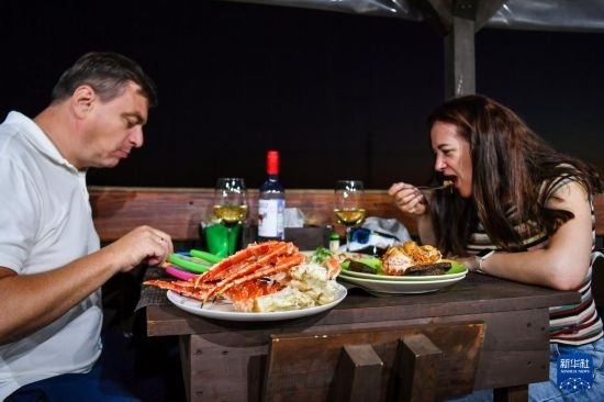 9月2日，食客們在俄羅斯符拉迪沃斯托克的一家餐館品嘗帝王蟹。新華社記者 曹陽 攝