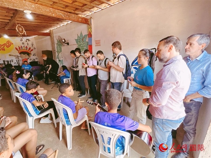  受益于中國企業(yè)的“青少年成長”項目，700多名當?shù)厍嗌倌甑囊魳泛妥闱驂粝氩迳狭顺岚?。圖為聯(lián)合采訪團正在采訪參加音樂培訓的孩子們。 人民網記者 陳一鳴攝