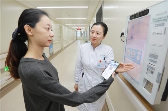 醫(yī)護(hù)人員引導(dǎo)患者在自助機(jī)前辦理自助入院手續(xù)。圖片來(lái)源：山東第一醫(yī)科大學(xué)第二附屬醫(yī)院