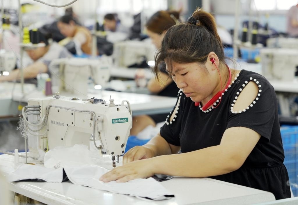 5月20日，村民在李寨村服裝加工廠內(nèi)忙碌。河南省周口市沈丘縣馮營鎮(zhèn)李寨村地處豫東平原。近年來，乘著脫貧攻堅(jiān)與鄉(xiāng)村振興政策的東風(fēng)，李寨村積極探索產(chǎn)業(yè)發(fā)展模式，通過“龍頭企業(yè)+村集體經(jīng)濟(jì)+農(nóng)戶”的方式，逐漸發(fā)展形成肉牛養(yǎng)殖、設(shè)施農(nóng)業(yè)、服裝加工、康養(yǎng)民宿等產(chǎn)業(yè)，以產(chǎn)業(yè)振興助力鄉(xiāng)村振興。新華社記者 李嘉南 攝