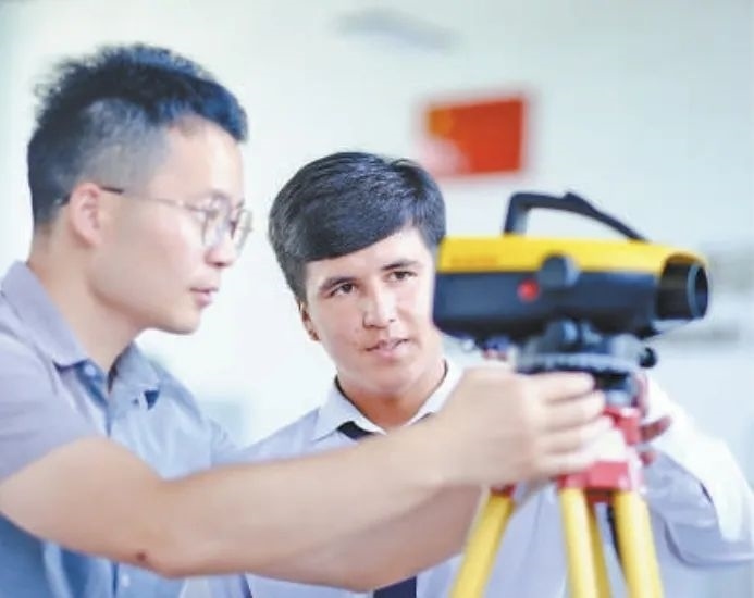 在塔吉克斯坦首都杜尚別的魯班工坊，來自天津城市建設(shè)管理職業(yè)技術(shù)學(xué)院的老師（左）為當(dāng)?shù)貙W(xué)生提供指導(dǎo)。新華社記者 鄭開君 攝