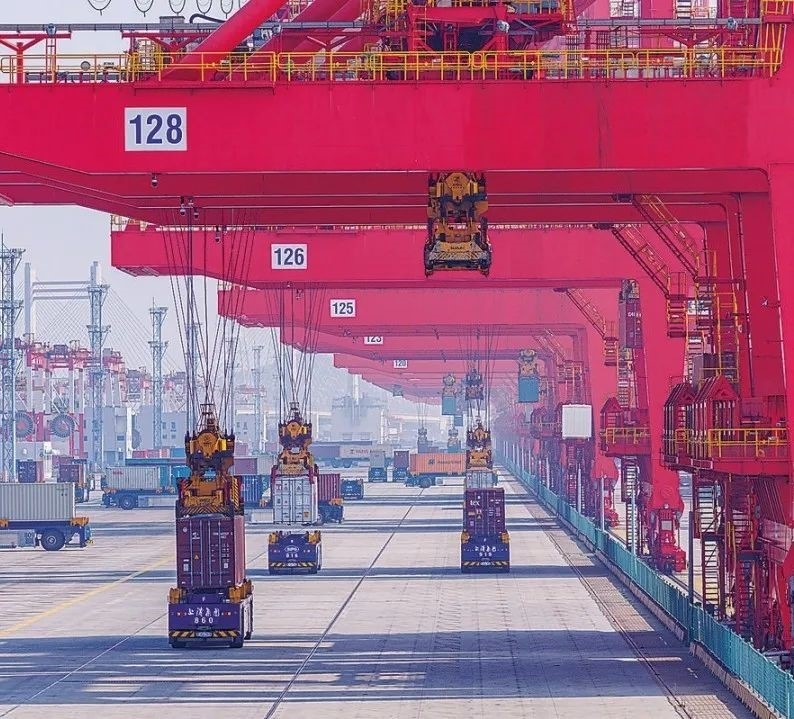 共建“一帶一路”國家在工作制度對(duì)接、技術(shù)標(biāo)準(zhǔn)協(xié)調(diào)、檢驗(yàn)結(jié)果互認(rèn)等方面強(qiáng)化合作、統(tǒng)一標(biāo)準(zhǔn)，貿(mào)易自由化便利化水平不斷提升。上海洋山港海關(guān)對(duì)接共建國家進(jìn)出口貨物相關(guān)標(biāo)準(zhǔn)，推動(dòng)通關(guān)一體化方式申報(bào)，提升通關(guān)效率。圖為無人駕駛的全自動(dòng)導(dǎo)引車在洋山港穿梭往來，搬運(yùn)集裝箱。王初 攝