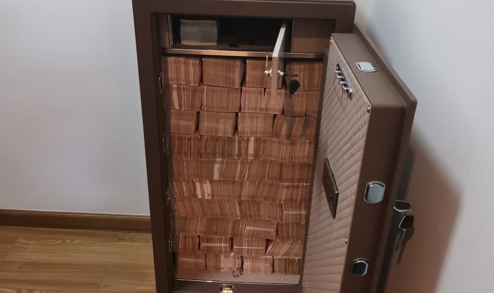 圖為警方查獲藏匿于保險柜中的現(xiàn)金。（警方供圖）