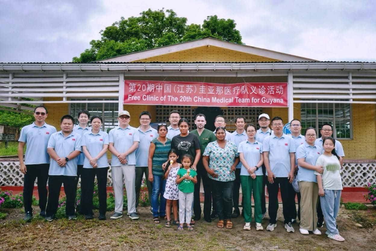 第20期中國(guó)（江蘇）援圭亞那醫(yī)療隊(duì)在圭偏遠(yuǎn)的林登高速社區(qū)開(kāi)展義診后，與部分當(dāng)?shù)鼐用窈嫌啊?中國(guó)援圭醫(yī)療隊(duì)供圖