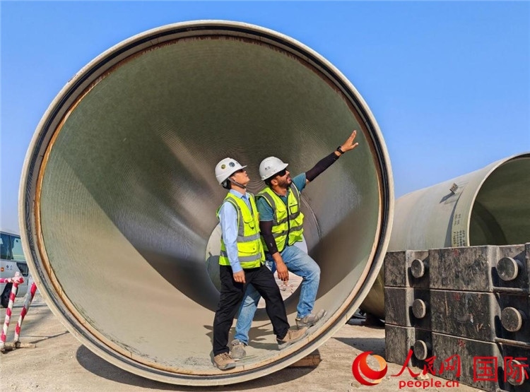 工作人員在察看輸水管情況。人民網(wǎng)記者 管克江攝