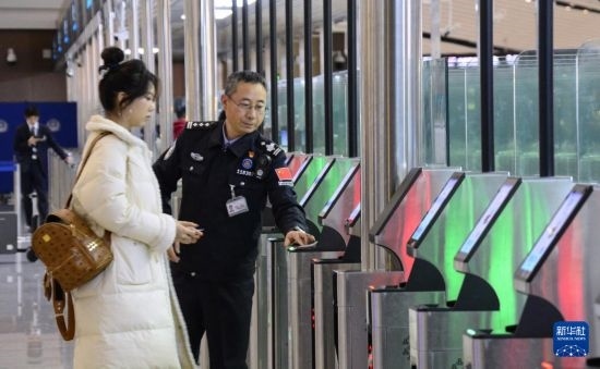 1月2日，大興機場邊檢站警察指導旅客使用自助出境設備。新華社記者 李欣 攝