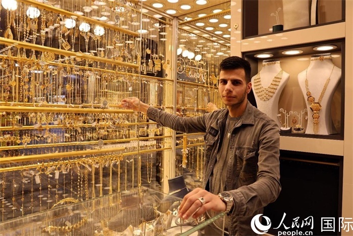 一名銷售員展示黃金飾品。人民網(wǎng) 伊納斯·易卜拉欣攝