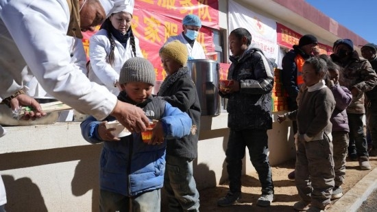 1月14日，廚師們正在給前來(lái)用餐的小朋友們打飯。新華社記者 邱星翔 攝