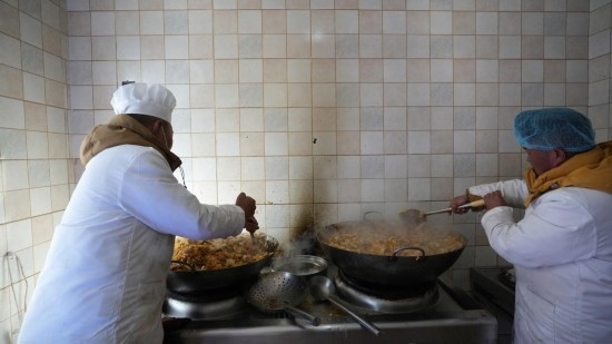 1月14日，服務(wù)隊(duì)的兩名廚師正在為村民們做午飯。新華社記者 邱星翔 攝