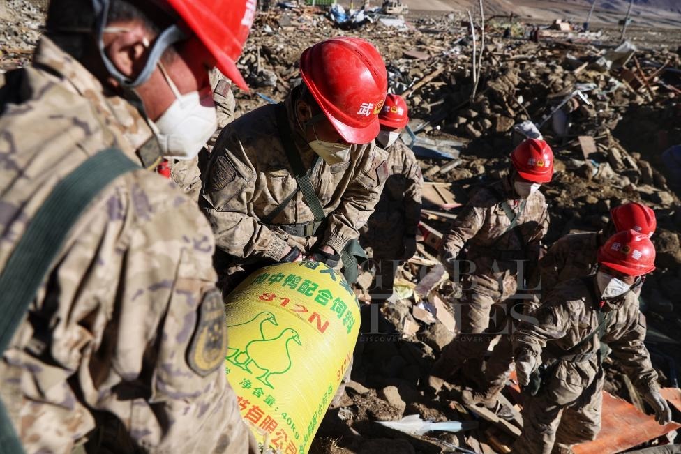 1月10日，定日縣長所鄉(xiāng)古榮村，武警官兵幫助受災群眾整理廢墟，搶救被掩埋的物資。環(huán)球時報記者崔萌攝