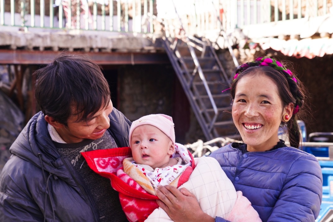 1月11日，在西藏日喀則市人民醫(yī)院，受災群眾抱著自己在地震中受傷的孩子康復出院。人民日報記者徐馭堯攝