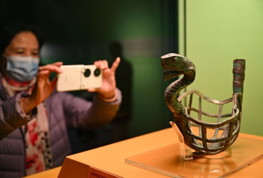 1月14日，觀眾在上海博物館蛇年迎春展拍攝展品蛇綱網(wǎng)狀銅器。新華社發(fā)（陳浩明攝）