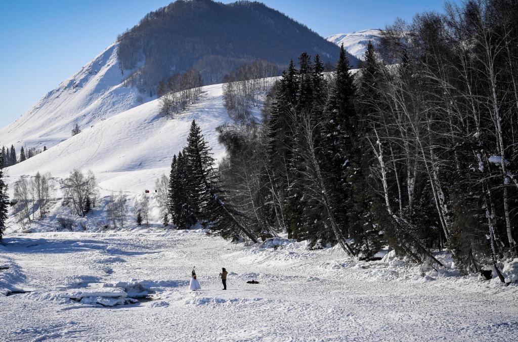 2024年2月5日，兩名游客在新疆阿勒泰地區(qū)布爾津縣禾木村拍照。新華社記者 馬鍇 攝