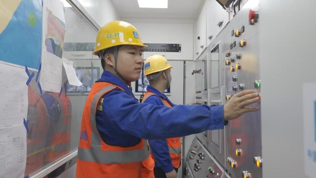 盾構(gòu)司機(jī)何曉波在駕駛室內(nèi)調(diào)試盾構(gòu)機(jī)參數(shù)。（劉芬攝）