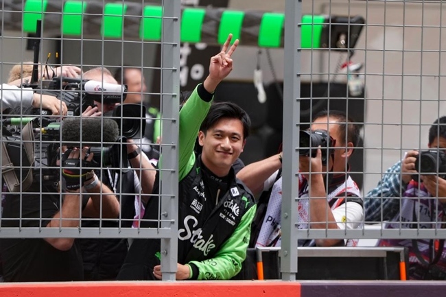 2024年4月19日，索伯車隊中國車手周冠宇（中）在練習(xí)賽前向觀眾致意。當(dāng)日，F(xiàn)1中國大獎賽在上海開賽。中國車手周冠宇主場首秀參賽。新華社記者 夏一方攝