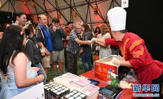 圖為游客在燈節(jié)現(xiàn)場購買小吃。（圖片由奧克蘭中國文化中心提供）