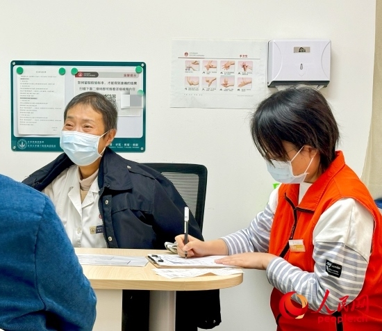 秦苑（中）接診患者。人民網(wǎng)記者 金慧慧攝