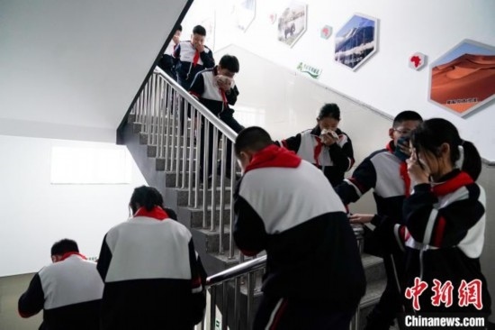  圖為學(xué)生們進(jìn)行應(yīng)急疏散演練。中新社記者 趙宇航 攝