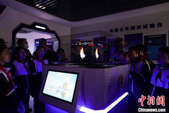 圖為學(xué)生們參觀道里區(qū)消防救援大隊消防科普體驗館內(nèi)幻影成像燃燒三要素實驗臺。中新社記者 趙宇航 攝