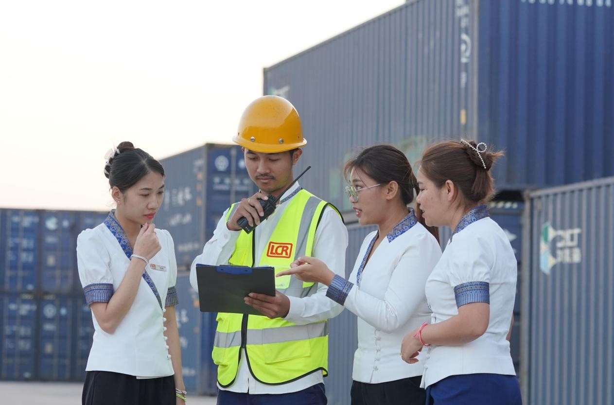 萬(wàn)象南站貨運(yùn)值班員陳尼啦（左一）與同事在一起討論工作。老中鐵路有限公司供圖