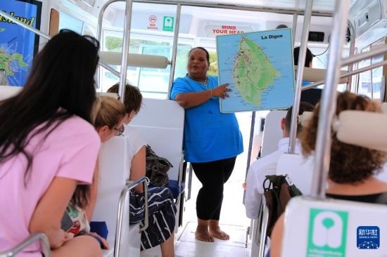 3月15日，一名導(dǎo)游在游艇上為游客介紹塞舌爾拉迪格島。新華社記者 董江輝 攝