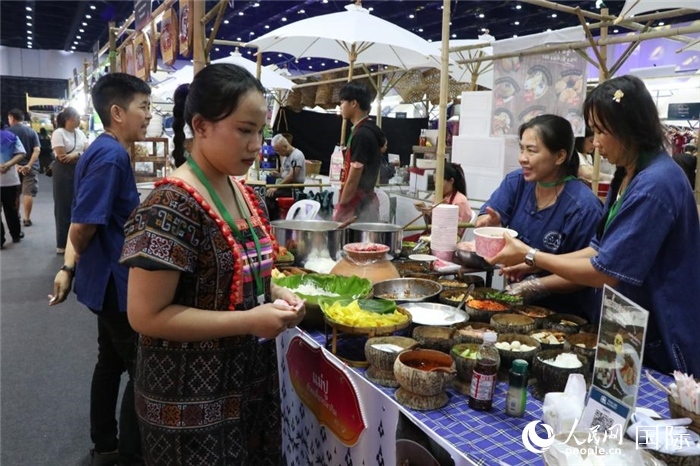 游客在攤位前購買特色美食。朱瀟逸攝