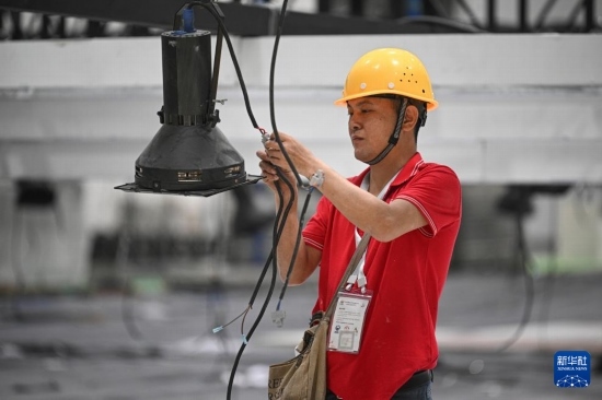 4月4日，工作人員在海南國(guó)際會(huì)展中心內(nèi)布設(shè)燈光。