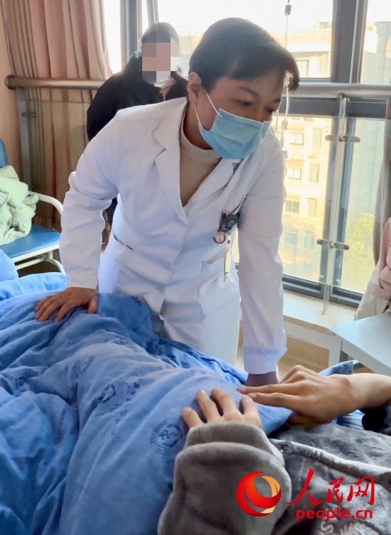 鄧茜查房時(shí)詢問患者情況。人民網(wǎng)記者 金慧慧攝